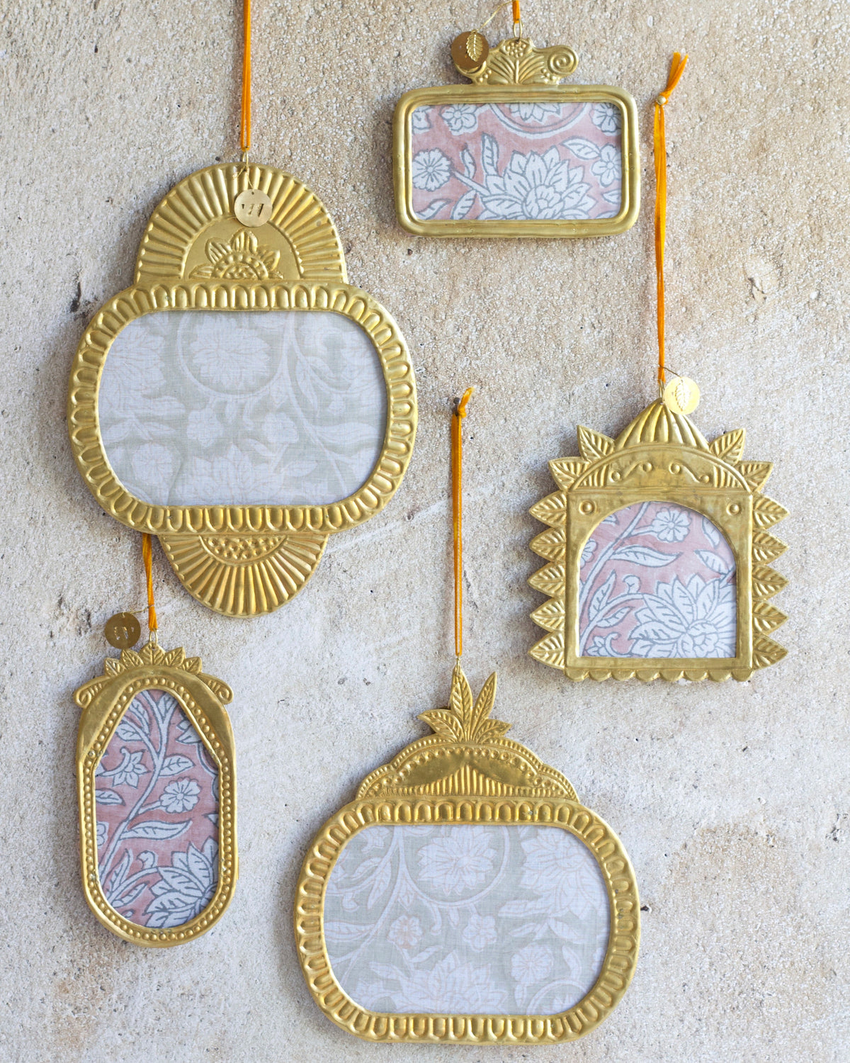 Set of decorative gold frames with floral patterns on a textured beige background