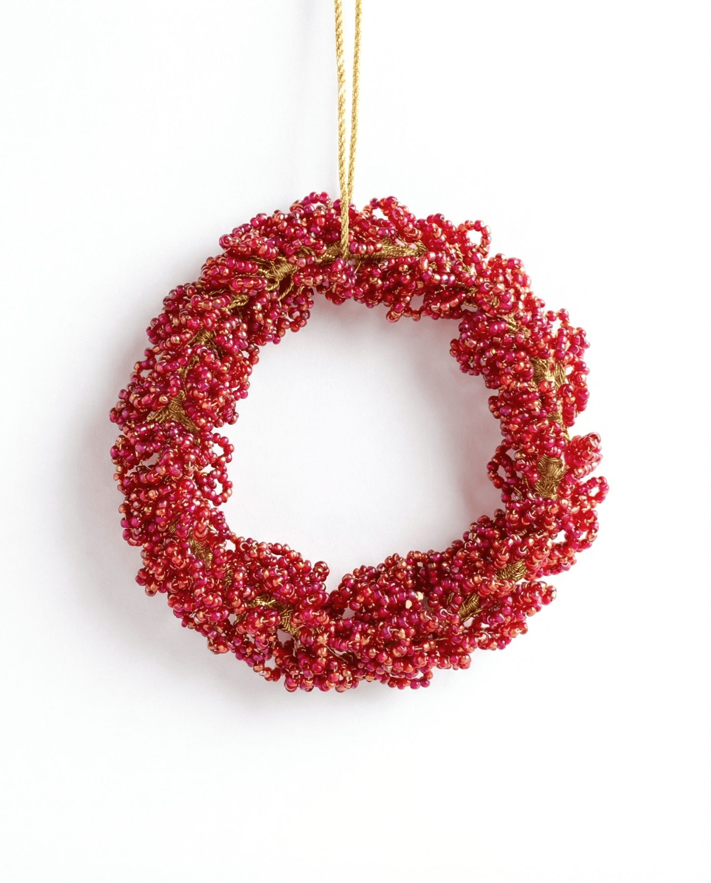 Red berry wreath hanging on a white background