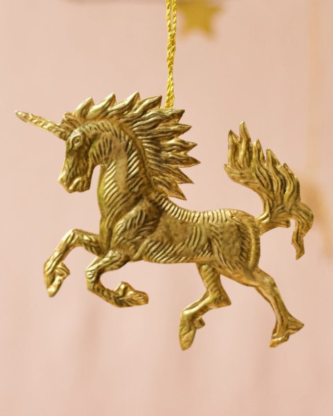 Gold unicorn ornament on a pink background