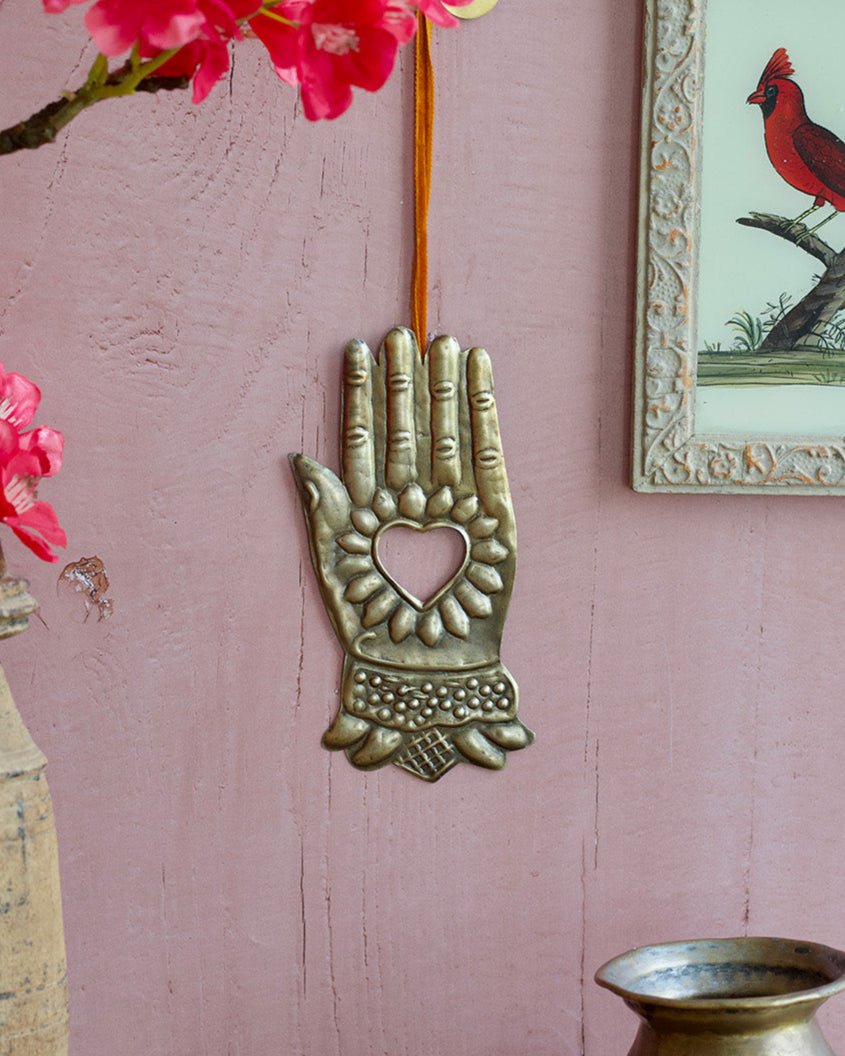 Decorative wall hanging with pink flowers and a framed picture of a cardinal on a pink wall.