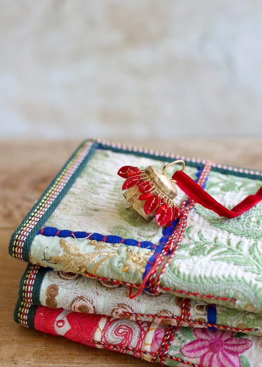 Stack of colorful embroidered fabric pieces on a wooden surface