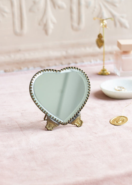 Small heart-shaped table mirror with brass feet and scalloped edge
