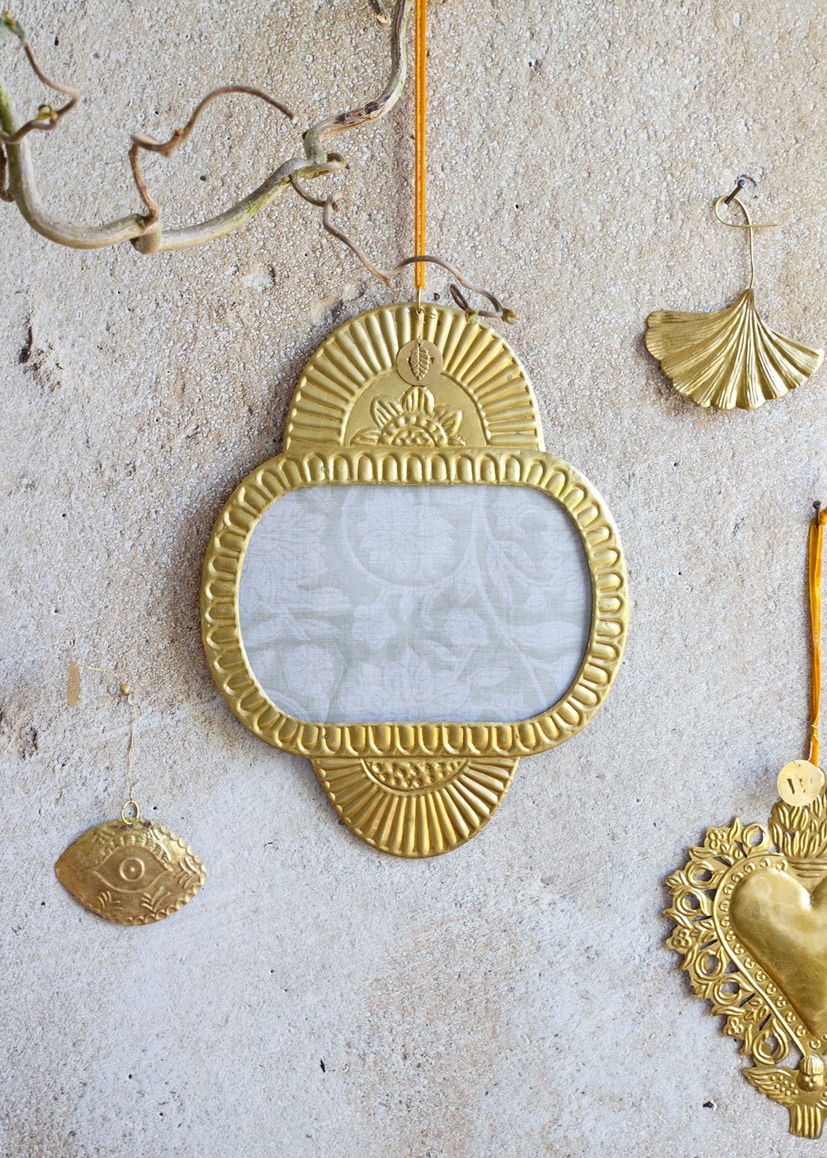 Decorative gold mirror with other ornaments on a textured surface