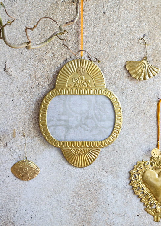Decorative gold mirror with other ornaments on a textured surface