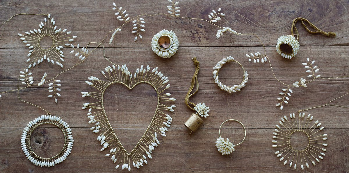 Decorative items including a heart-shaped wreath, floral arrangements, and string art on a wooden surface.