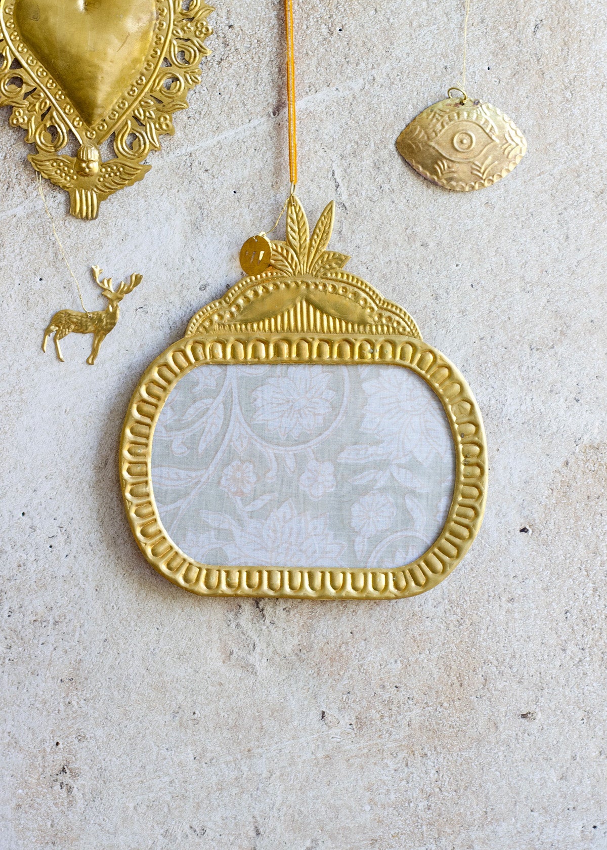 Decorative gold mirror with intricate designs on a textured surface