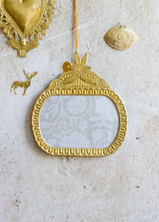 Decorative gold mirror with intricate designs on a textured surface