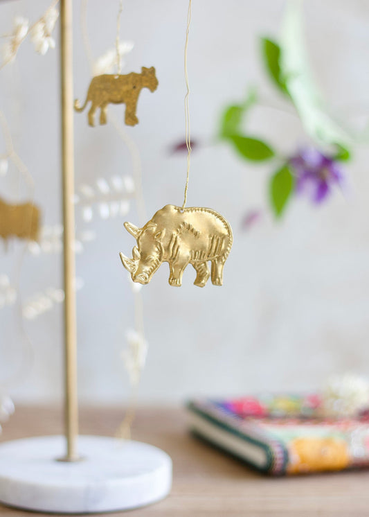 Gold rhino ornament on a stand with blurred background