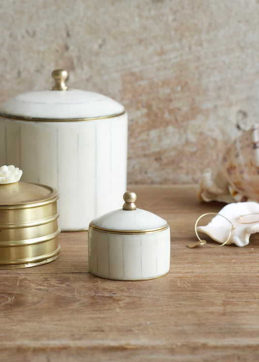 Set of ceramic jars with gold accents on a wooden surface