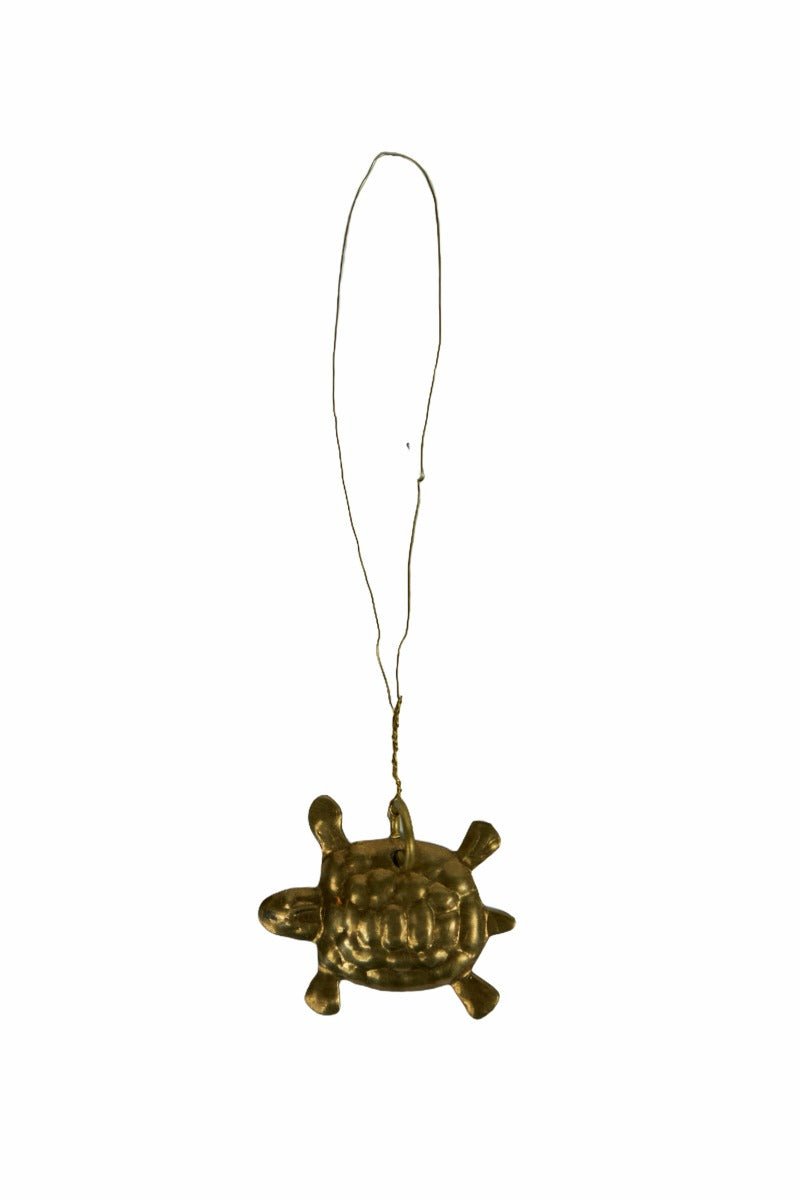 Brass turtle ornament with hanging wire on white background