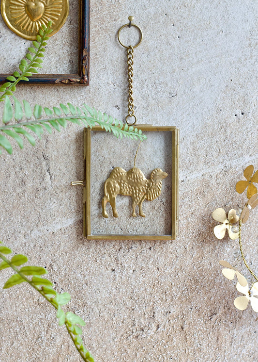 Decorative wall hanging with a gold frame and animal design on a textured wall.