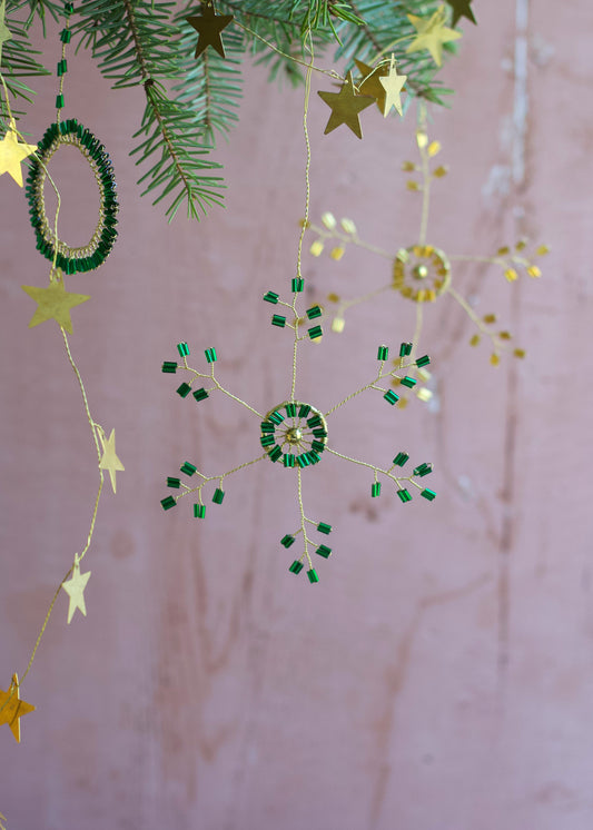 Decorative string with stars and green circular ornaments on a pink background