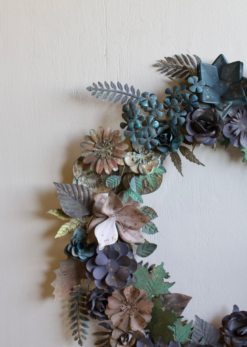 Handgemaakte metalen bloemenkrans in zachte blauw- en groentinten
