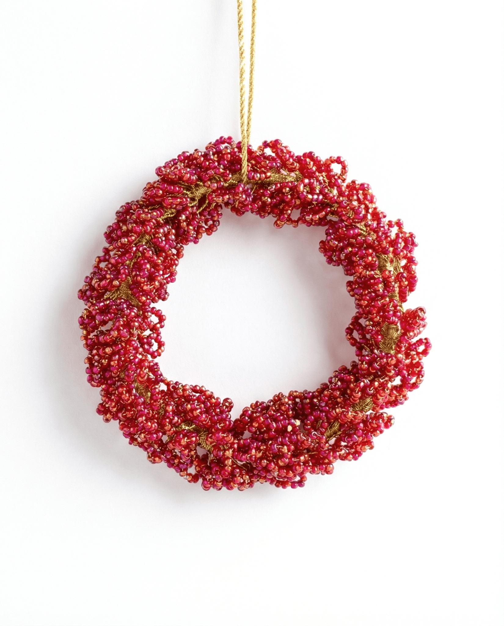 Red berry wreath hanging on a white background