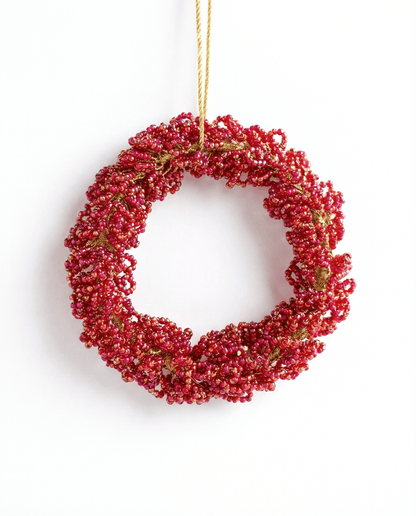 Red berry wreath hanging on a white background