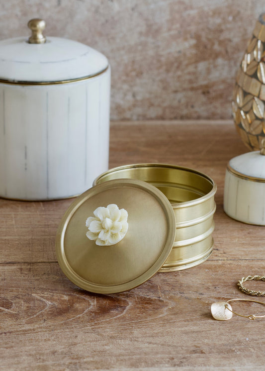 Gold jewelry box with a decorative lid on a wooden surface