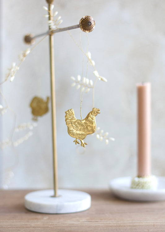 Gold rooster ornament on a stand with blurred background