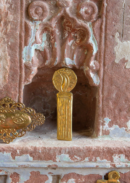 Decorative gold object on a textured pink surface