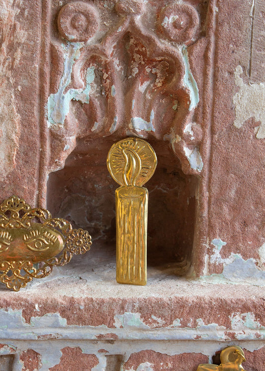 Decorative gold object on a textured pink surface