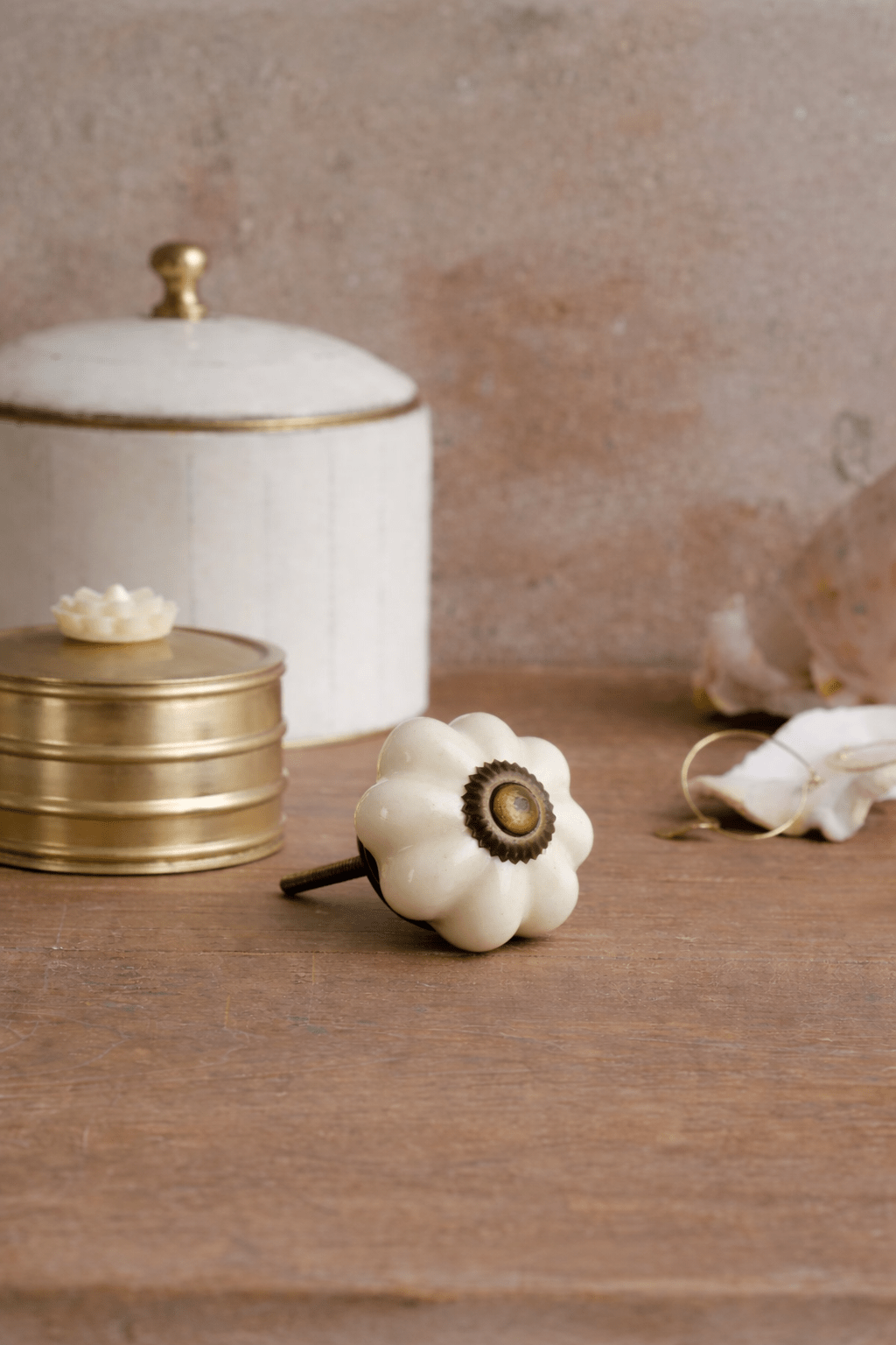 Decorative white pumpkin with gold center on a wooden surface with a neutral background