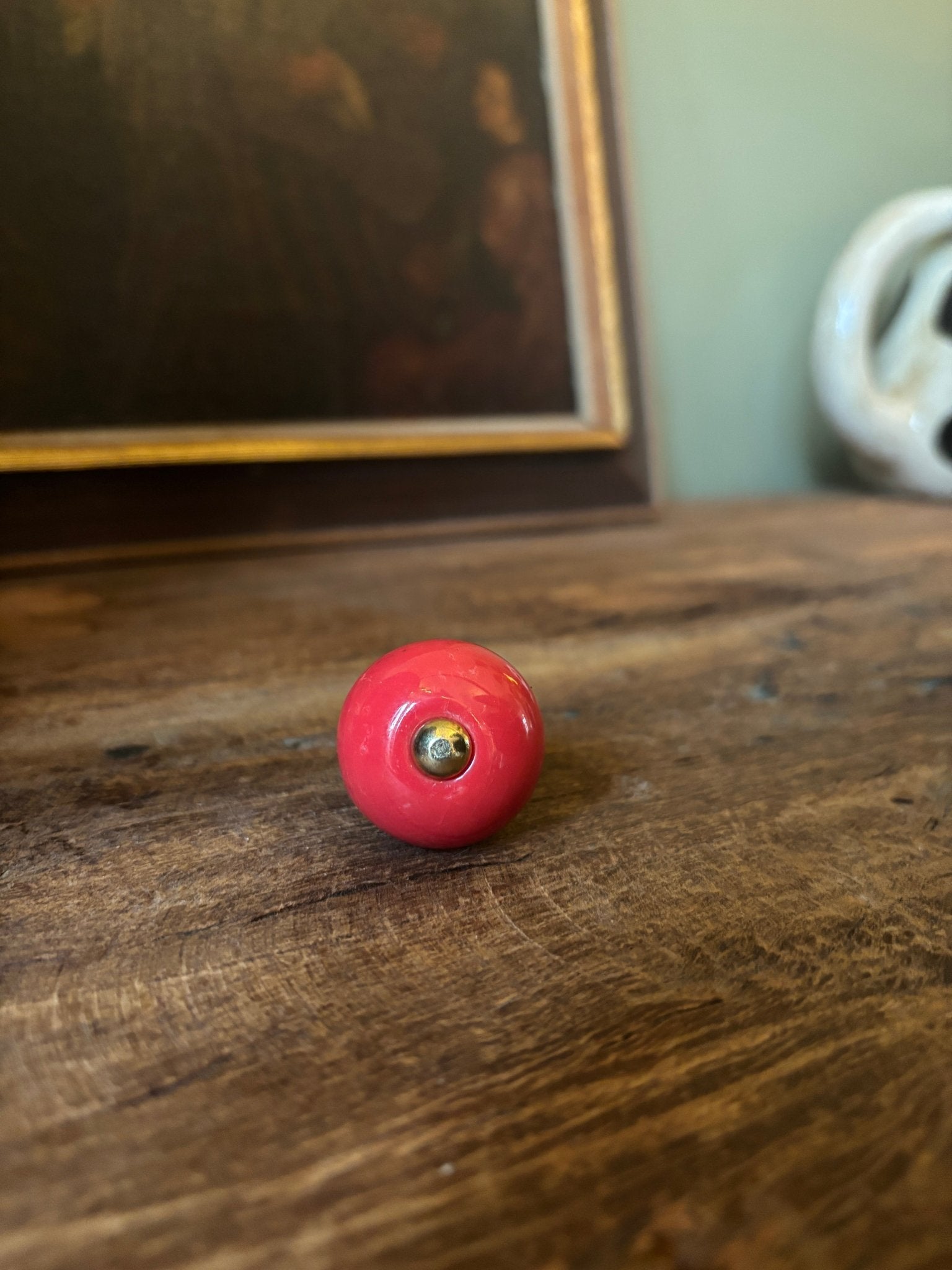 Red ball with a central hole on a wooden surface