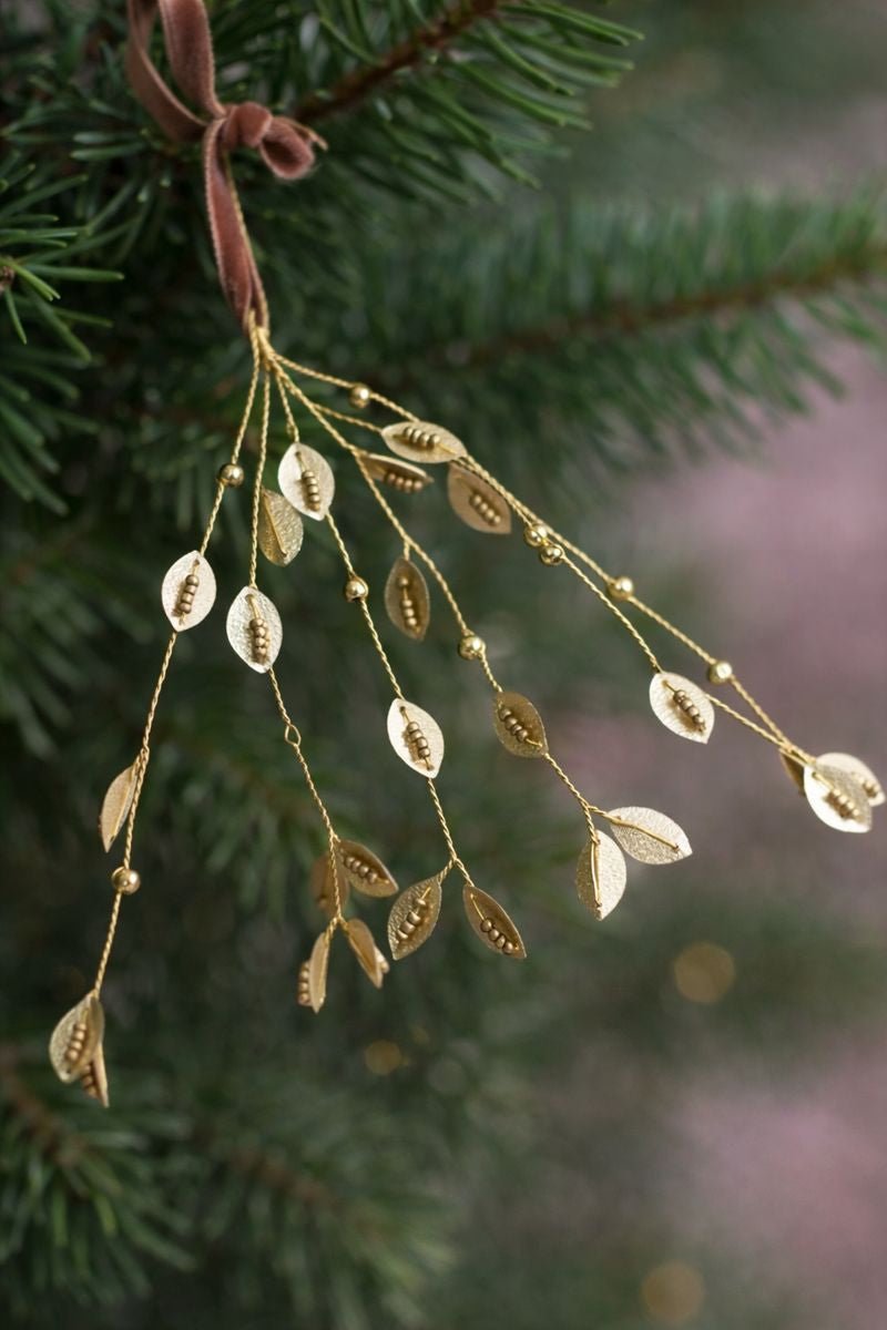Gold leaf ornament hanging on a Christmas tree