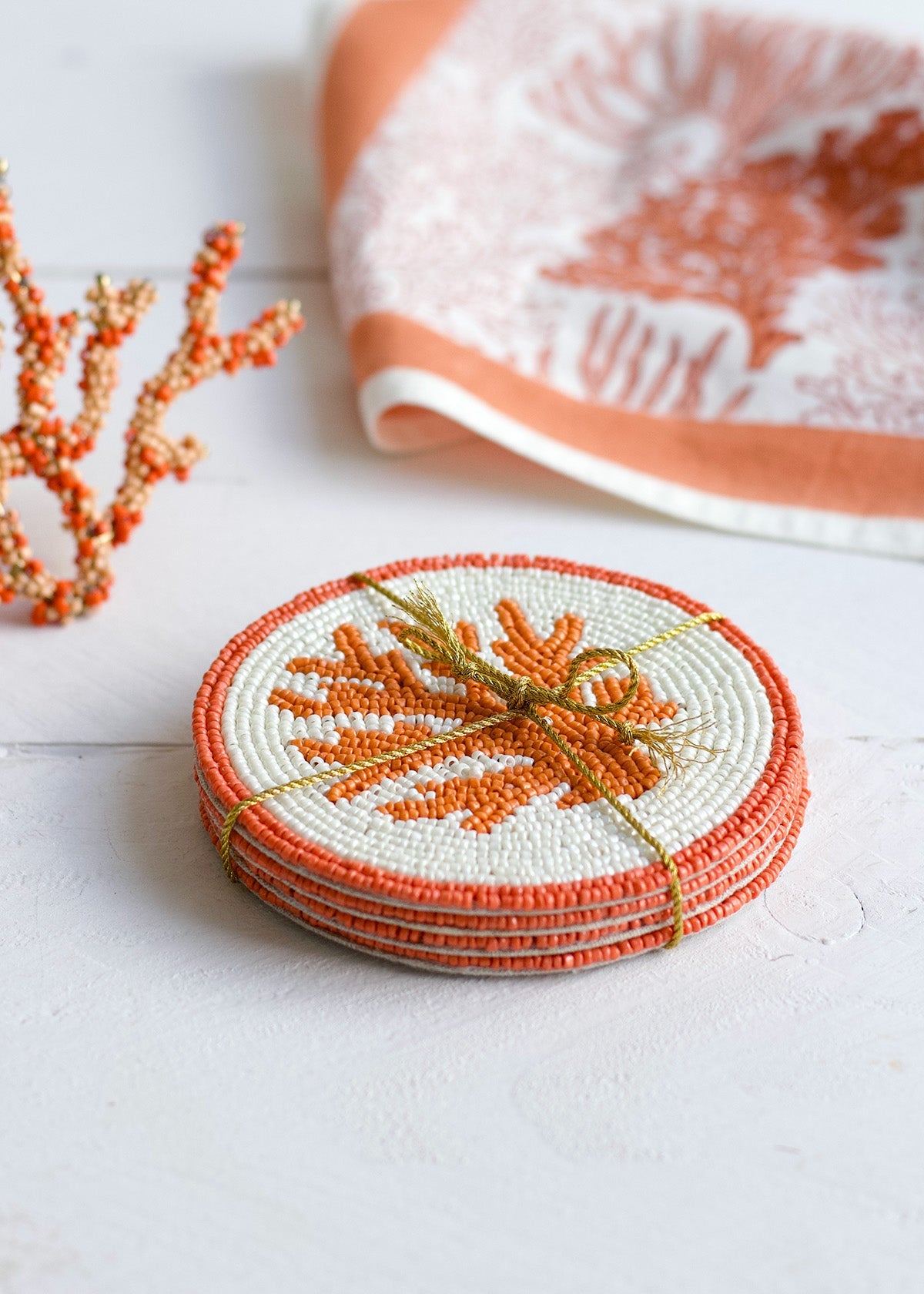 Set of orange coasters with a decorative design on a white surface.