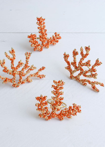Set of four orange coral-shaped earrings on a white background