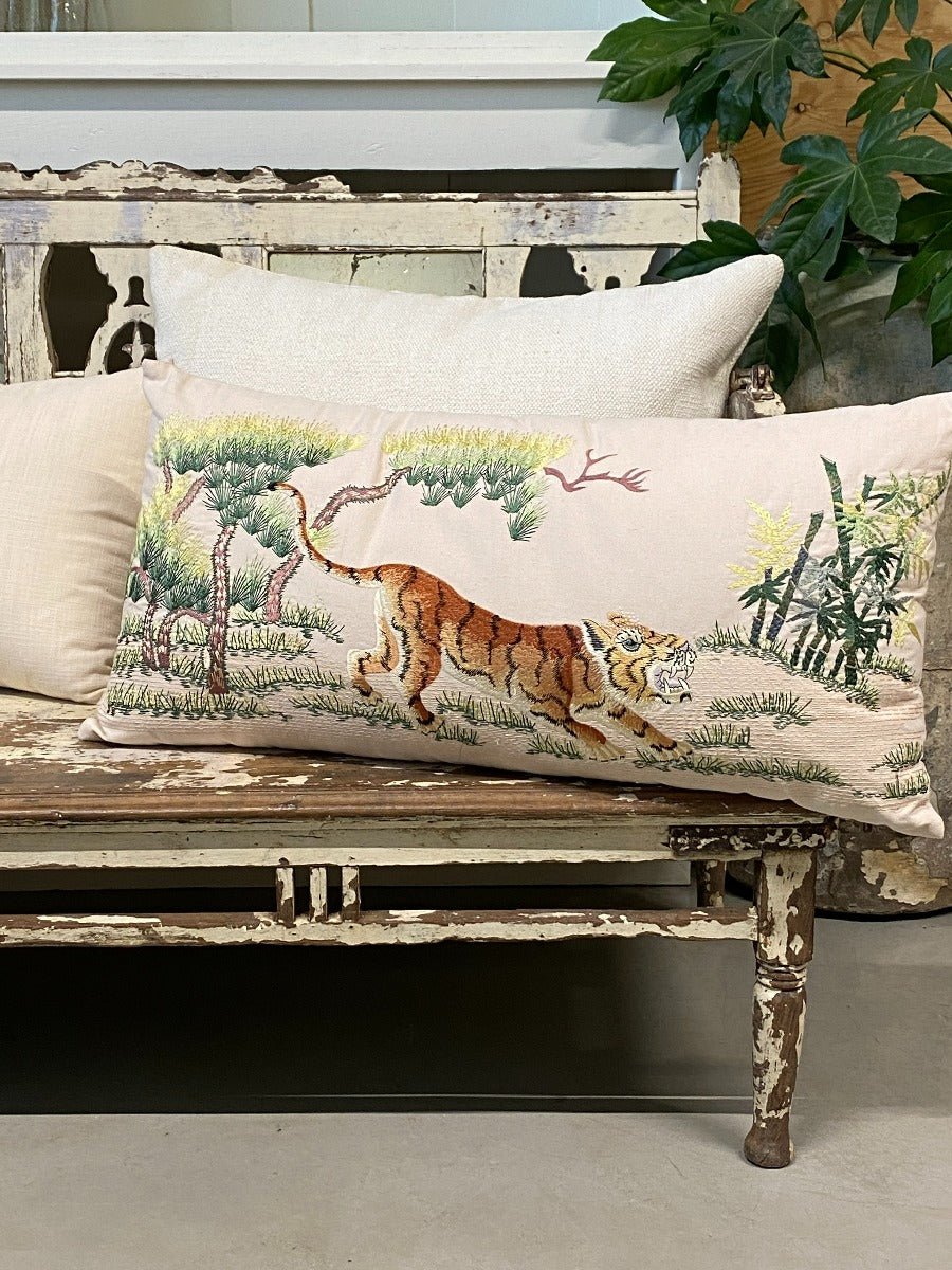 Decorative pillow with a tiger design on a wooden bench