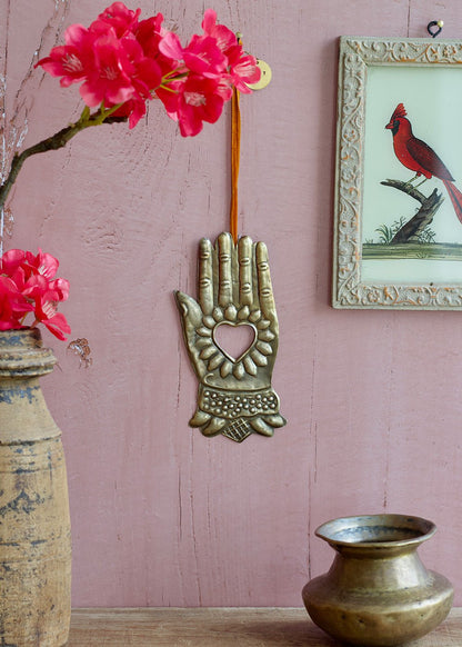 Decorative wall hanging with pink flowers and a framed picture of a cardinal on a pink wall.