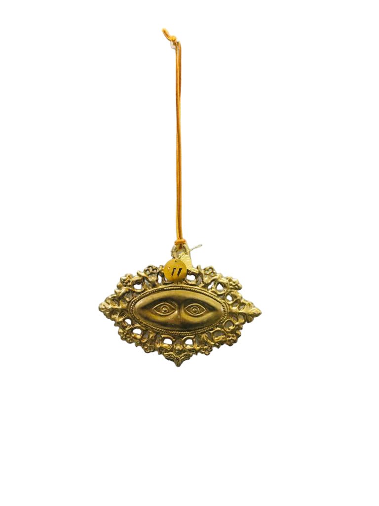 Decorative gold ornament with eye design on a white background