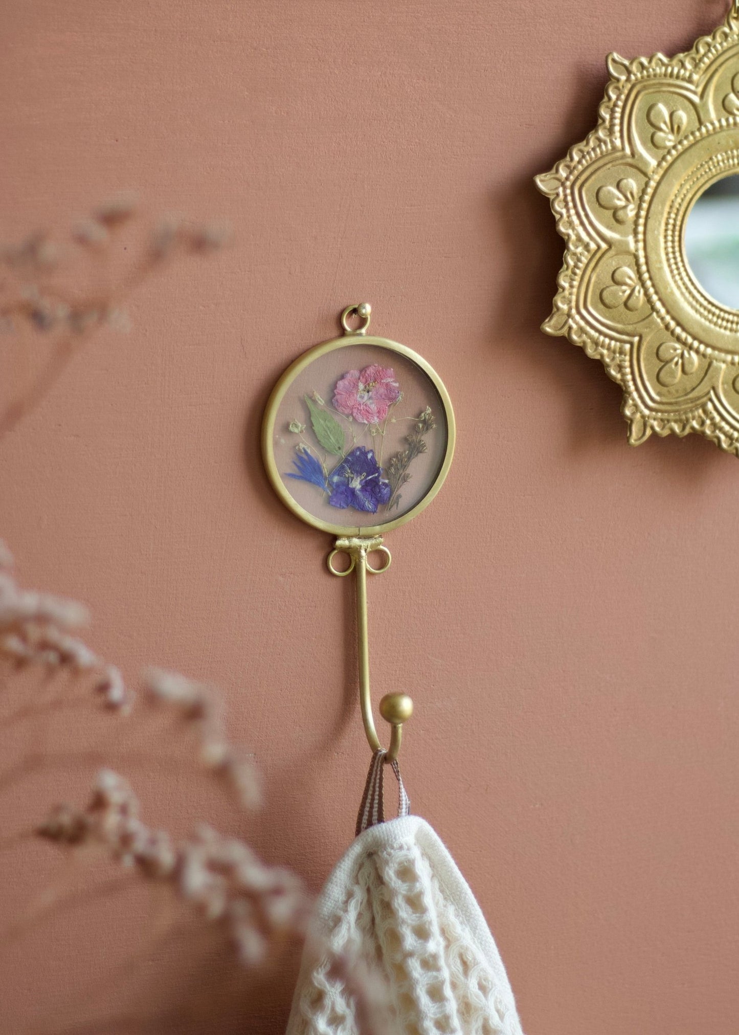 Decorative wall hook with floral design on a pink wall
