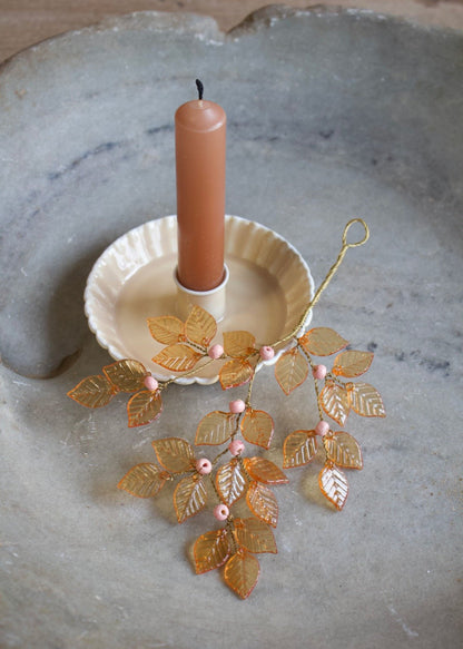 Goudkleurige blaadjes met roze kralen