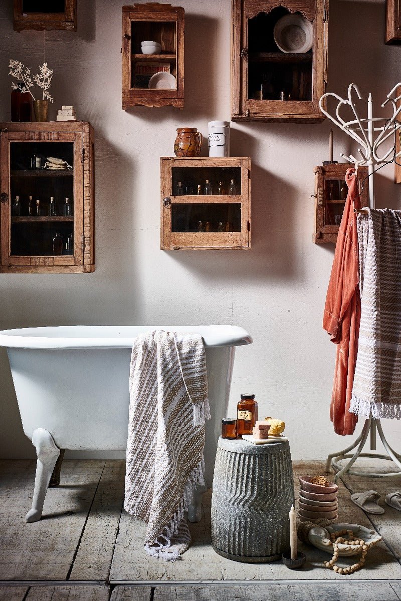 Bathroom with clawfoot bathtub, wooden cabinets, and rustic decor.