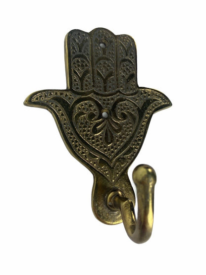 Brass colored metal wall hook with floral pattern on white background