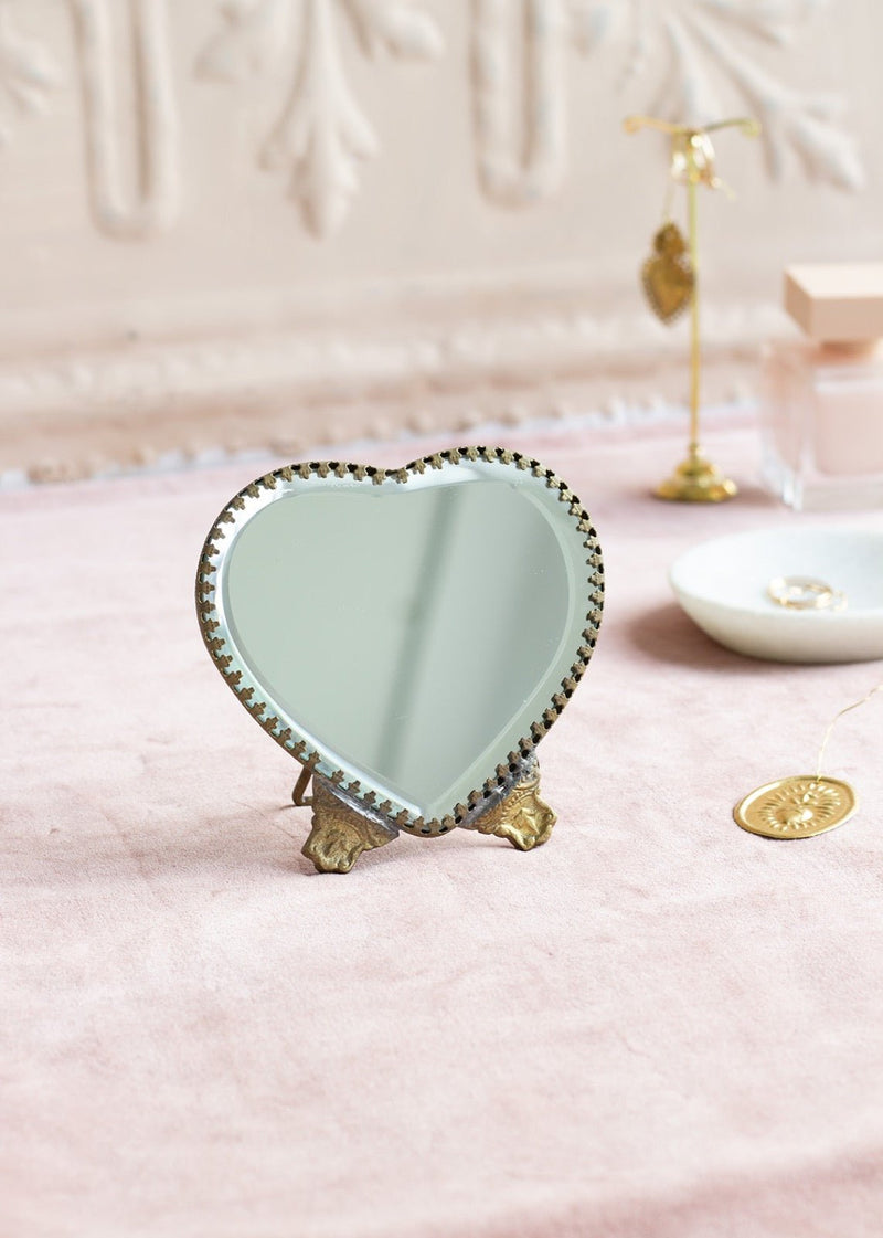 Small heart-shaped table mirror with brass feet and scalloped edge
