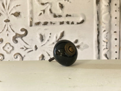 A black round knob with a geometric pattern in the background.