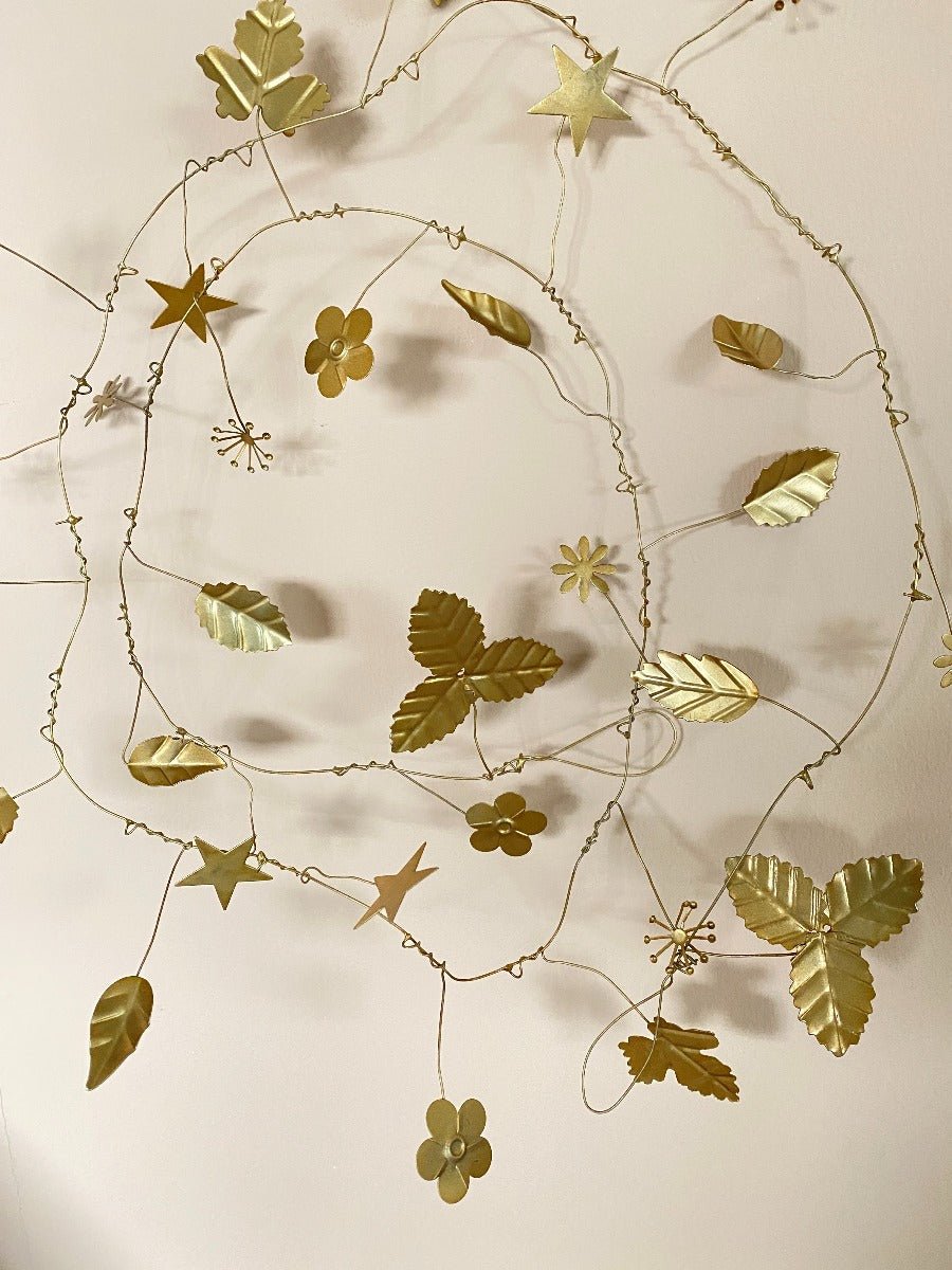 Decorative wreath with gold leaves and stars on a beige background