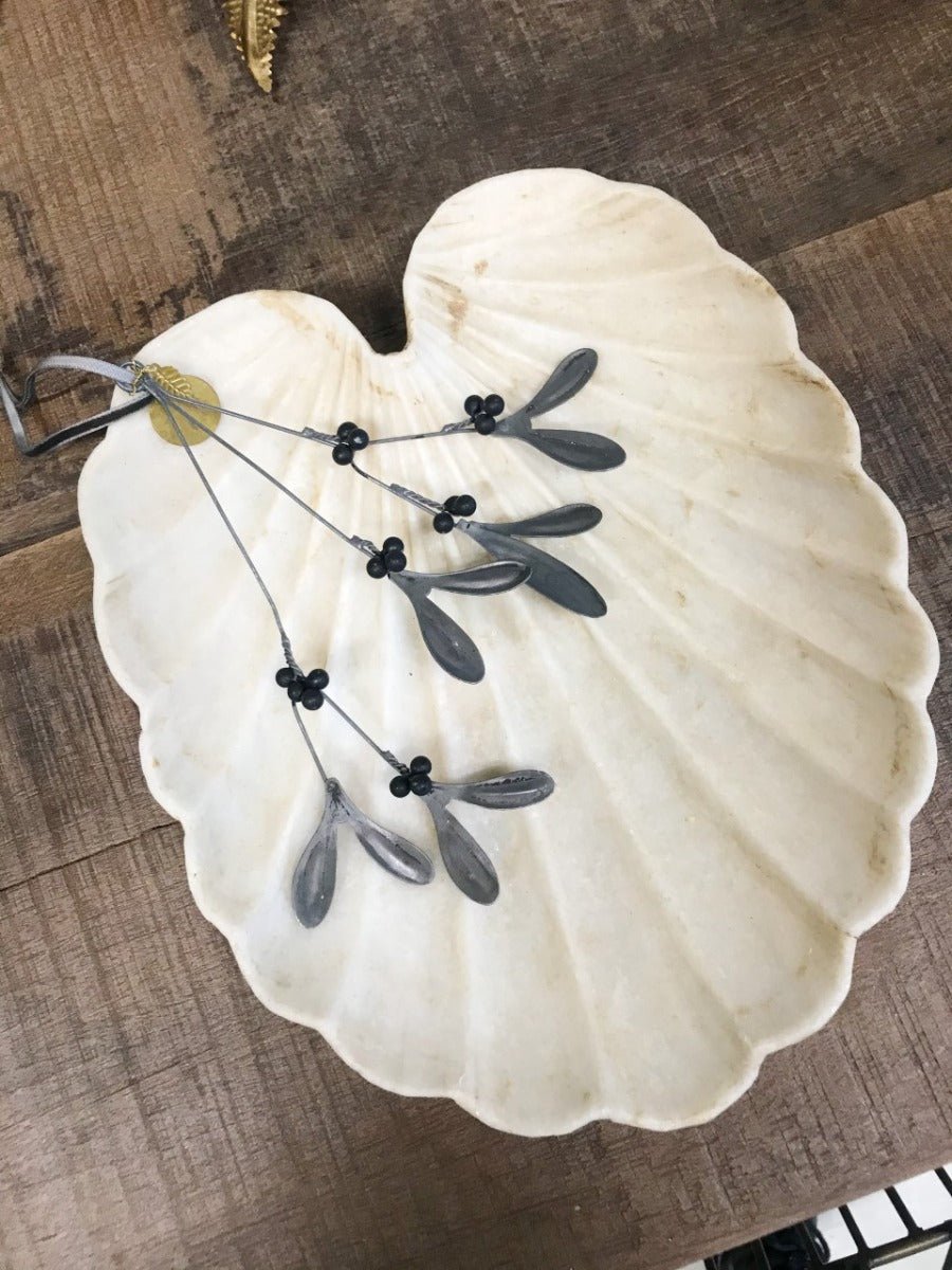 Decorative white shell with black decorative elements on a wooden surface