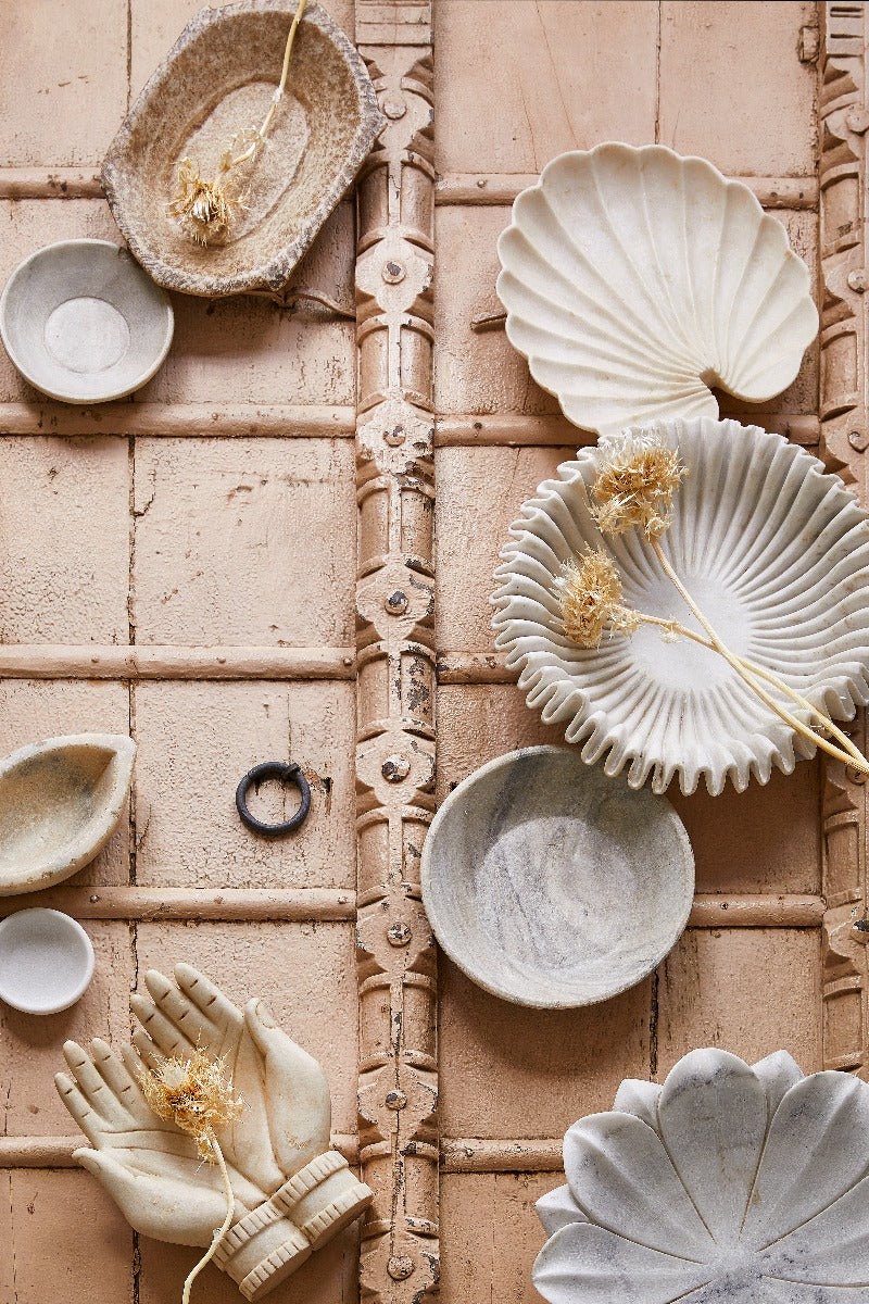 Ceramic plates and bowls with shell designs on a decorative tile background