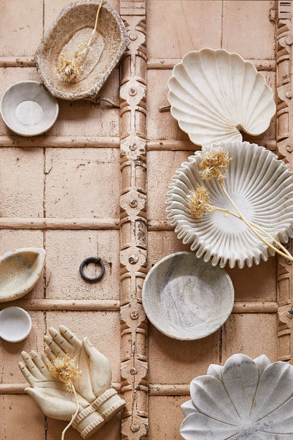 Ceramic plates and bowls with shell designs on a decorative tile background