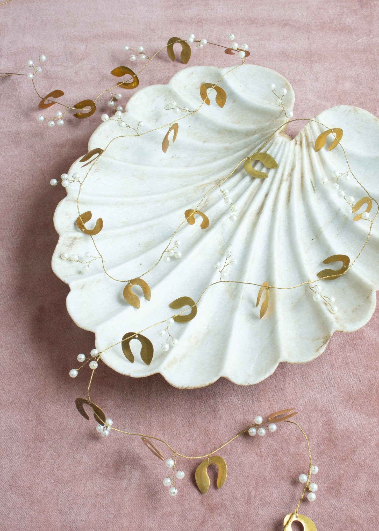 Decorative shell with gold horseshoe designs on a pink background