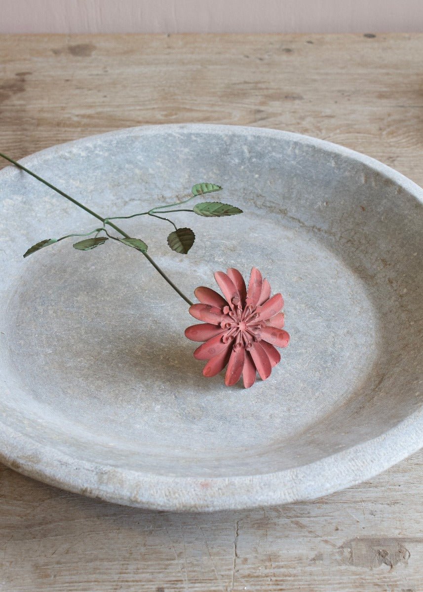 Handmade coral metal flower with green leaves on a wire stem