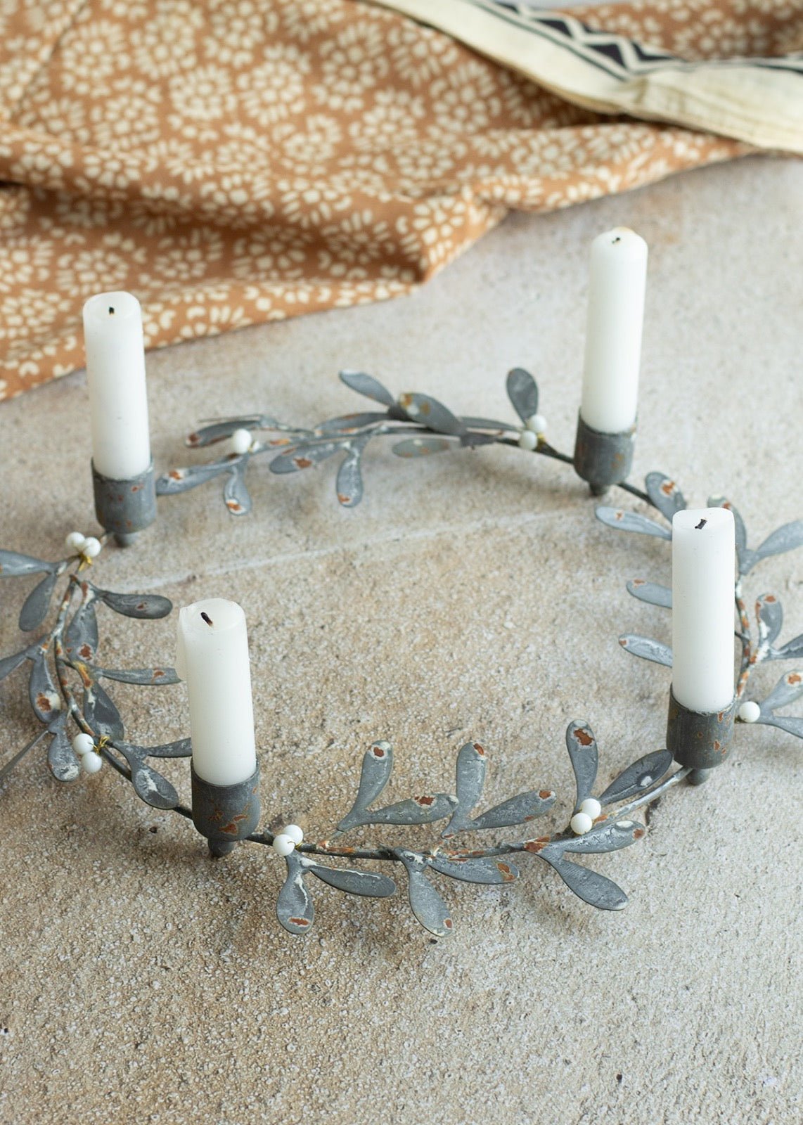 Decorative wreath with candles on a textured surface