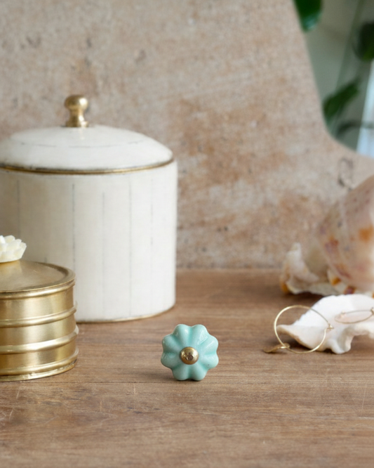 Decorative turquoise knob on a wooden surface with a neutral background