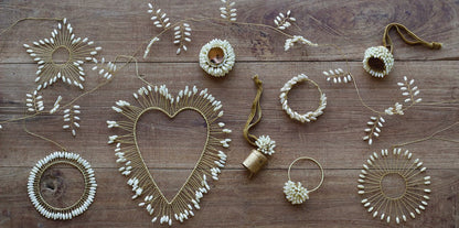 Decorative items including a heart-shaped wreath, floral arrangements, and string art on a wooden surface.