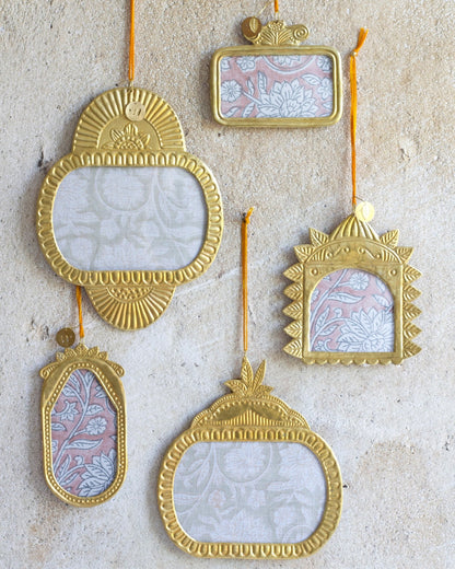 Set of decorative gold frames with floral patterns on a textured beige background