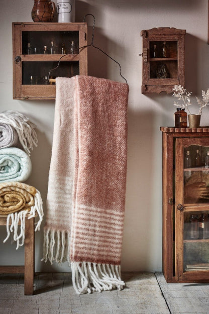 pink plaid hanging on a black hanger with decorative wooden furniture