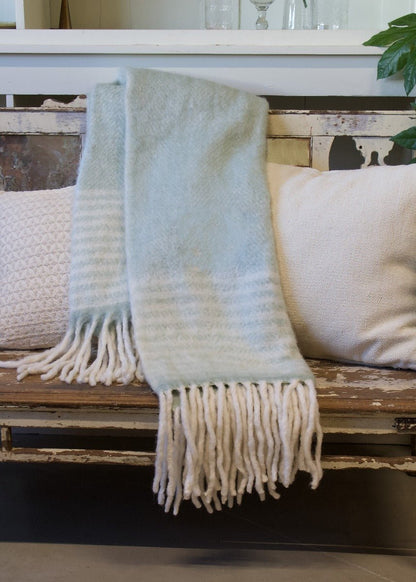 Green plaid on a white wooden chair with decorative white cushions