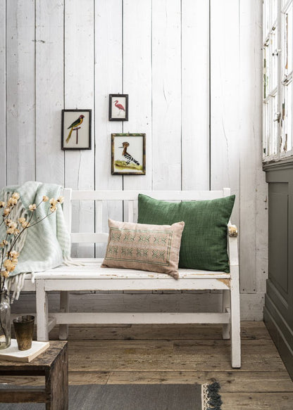 Green plaid on a white wooden chair with decorative beige & deep green cushions